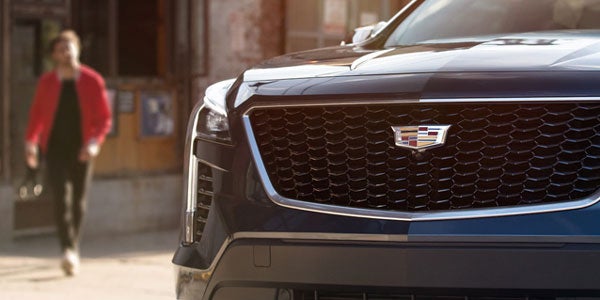 Black Cadillac XT5 driving on a road