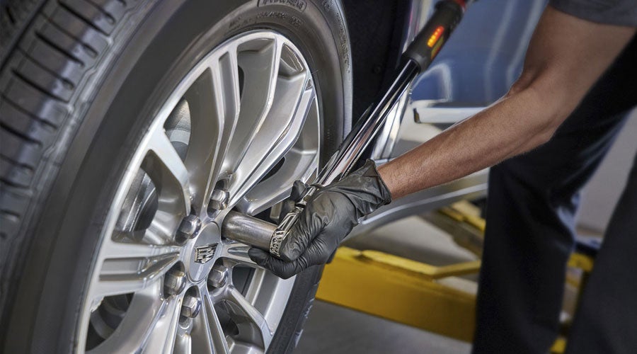 Professional Cadillac Service mechanic changing the tires of a car