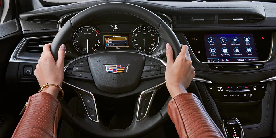 Hands on the steering wheel of a new Cadillac